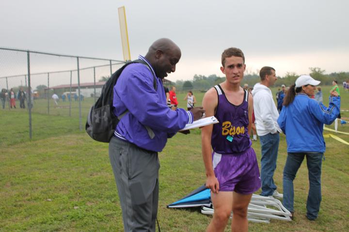 Sophomore+Nathanial+Young+checks+in+with+coach+Pat+Roberts+during+the+district+cross+country+meet+at+Blooming+Grove.+The+meet+continued+despite+rain+throughout+the+day.
