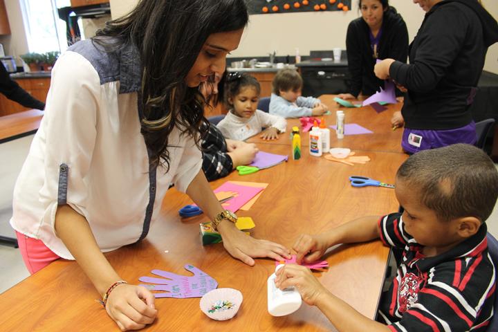 Junior Ekta Patel helps one of the kindergarteners with her project. The FCS students spent most of the day working with the younger students.