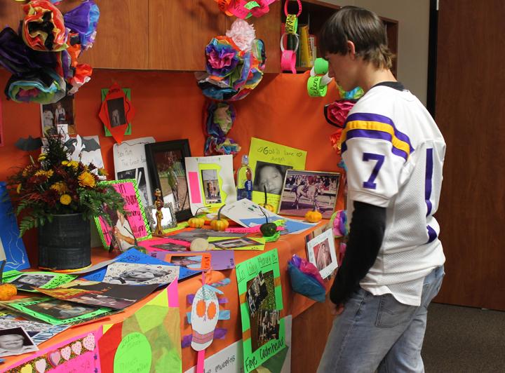 Sophomore Bryce Fulmer looks at the display that students put together for their Dia de los Muertos celebration in Spanish class.