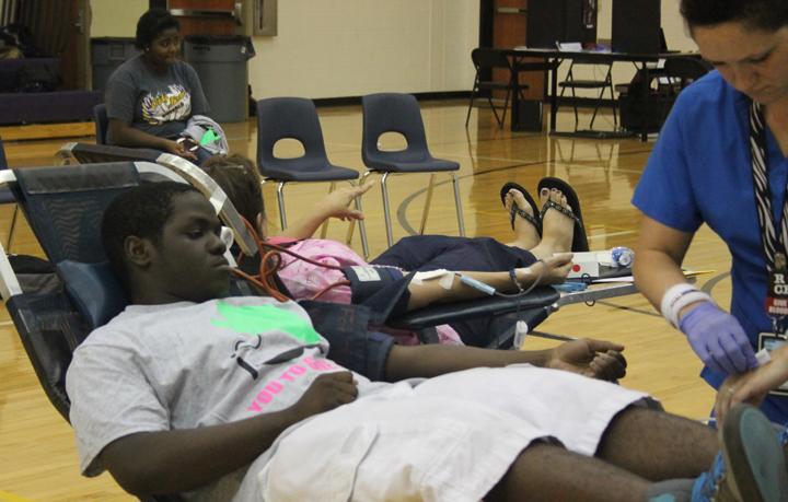 Sophomore Richard Walker watches while the tech gets ready to draw his blood during the blood drive.