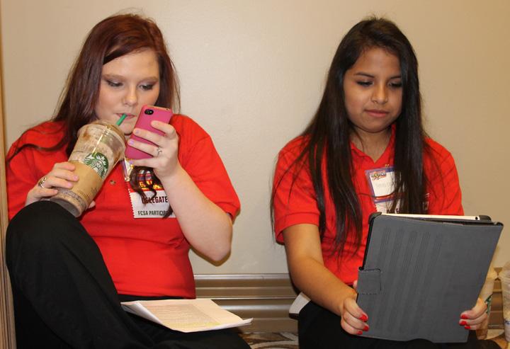 Sophomore Brianna Johnston checks her text messages while Annel Escobar studies for her contest. Late-night cramming sessions the night before meant that the students were glad to find a Starbucks the next morning.