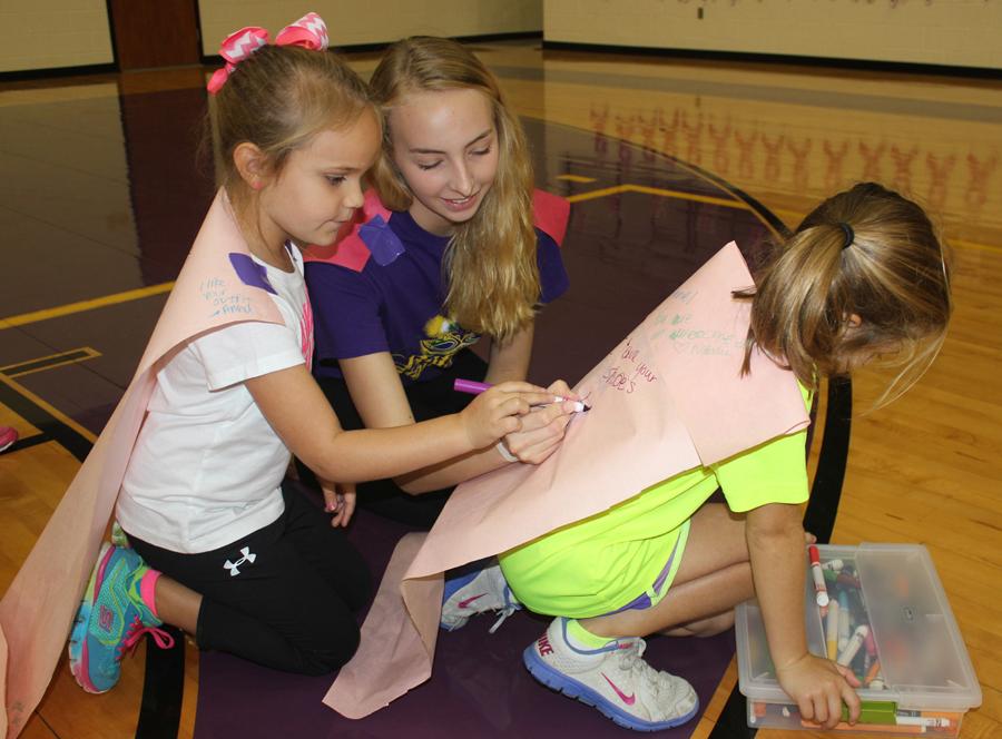Bison Belle Josefine Poels helps two camp-goers with their capes. The children wrote kind things about one another on their capes. 
