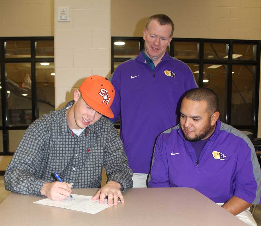 Senior Kyrell Miller signs with SHSU while athletic director Gary Grubbs and coach Ray Ramos look on.