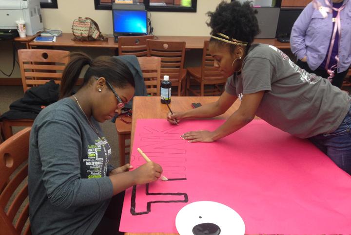 Student Council members Shekinah Amos and Jordan Jenkins work on a poster during Teen Summit. The posters were used in the video later in the week.