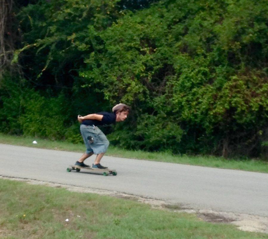 Senior+David+McAlpine+adds+some+miles+to+his+longboard.+The+student+uses+his+longboard+to+get+from+school+to+work+at+Brookshire+Bros.+each+day.