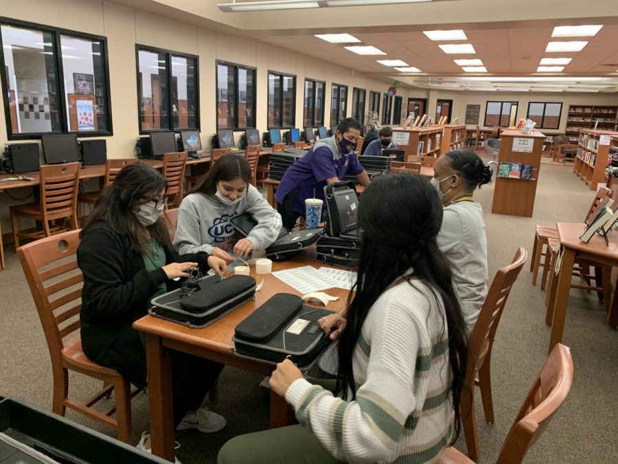 Journalism students help Assistant Principal Lu Olvera, library aide Percillar Reed and Librarian Melonie Menefee with Chromebook processing. The devices had to be barcoded before distribution.