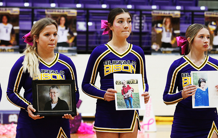 Cheerleaders Abby Brewer, Nicollette Arabie and Madison Gilliam hold pictures of their loved ones during the Pink Out Pep Rally.