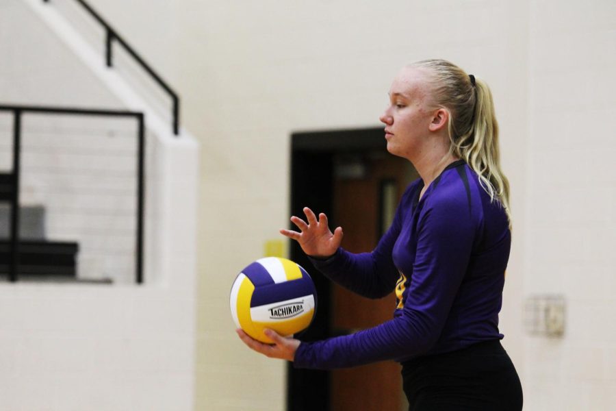 Junior Mollie Hirsch gets ready to serve the ball during a home volleyball game.