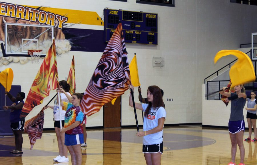Color+Guard+members+Jamie+Phillips%2C+Emmelee+Weathers+and+Morgan+Altom+hold+their+flags+while+Belle+Jessica+Kaiser+gives+hers+a+twirl.+The+Belles+and+color+guard+members+worked+together+during+summer+practices+on+routines.+The+two+groups+and+the+band+are+working+together+on+a+new+style+of+halftime+performance.