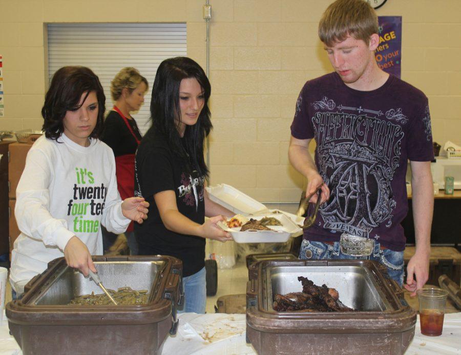 Seniors Chelsea Brewer, Morgan Altom and Jacob Davis serve the steak dinners at last weeks fundraiser. The senior class came away with more than $12,000 to use on graduation night.