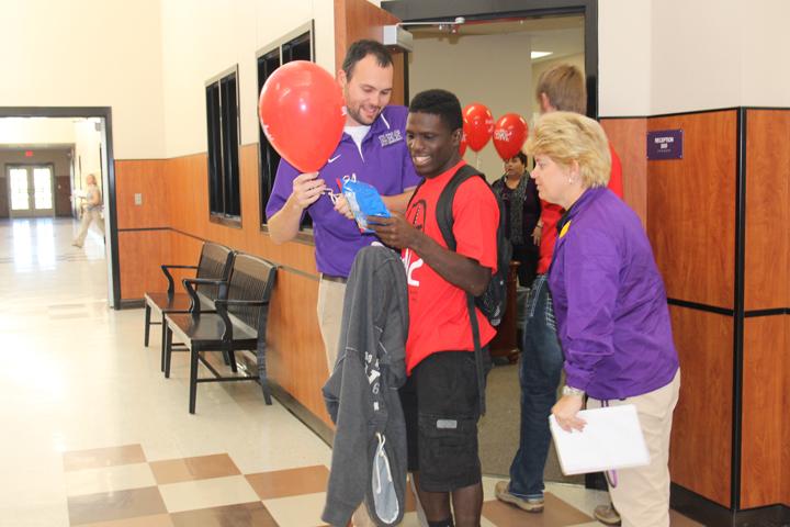 Senior Adam Simpson checks out his Celebrate My Drive prize while Principal Tracy Gleghorn and Assistant Principal Matthew Quick try to talk him out of some of his treats. Student names were drawn daily for prizes all week.