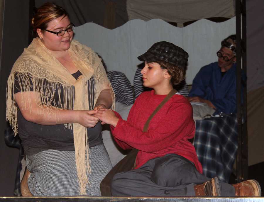 Katelyn Cannon, playing Charlie Buckets mom, comforts Charlie (played by Kendall Morales) when he does not win a ticket.