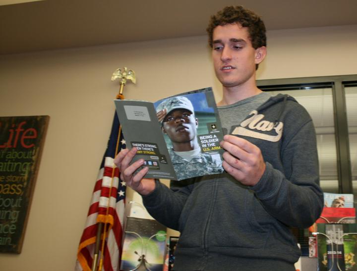 Junior Nathanael Young checks out a flyer on entering the military in the library. Young hopes to go into the army after high school.