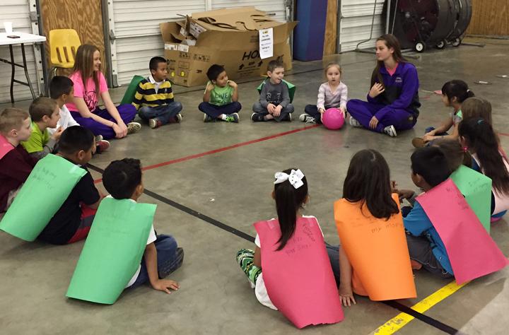 Students Lauren Pate and Hannah Eakin work on an anti-bullying activity with a group of elementary students. 