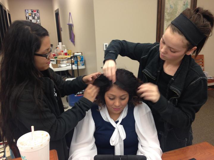 Crew members Karina Sotelo and Taryn Morman work on hair and makeup for junior Brittnie Garcia.
