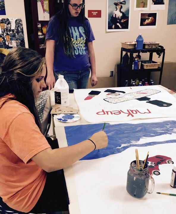 Sophomore Kassidy Bell works on her poster in art class.