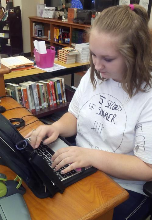 Senior Sarah Burchfield works on a journalism assignment during activity period.