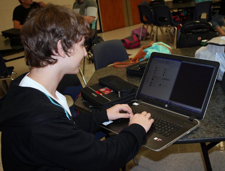 Freshman Josh DeVaney plays on his laptop during lunch. 
