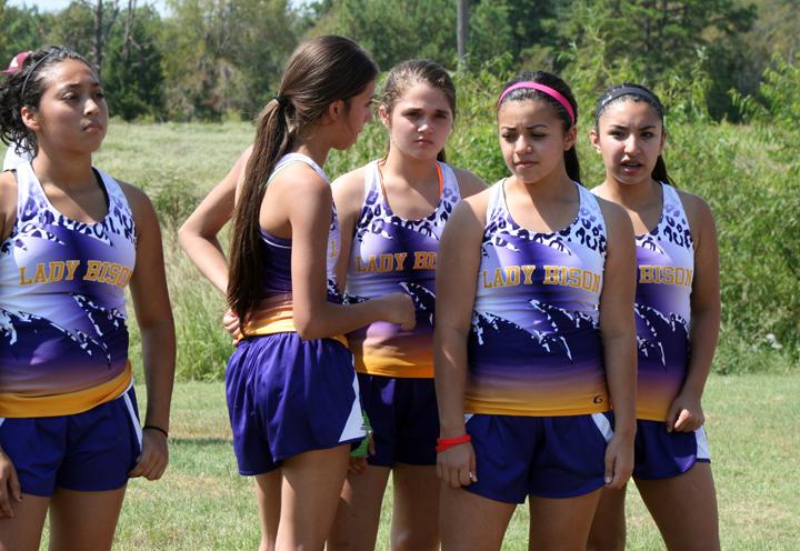 Cross country runners Nadia and Andrea Garcia chat with teammates before their competition. The two sisters practice and compete together.