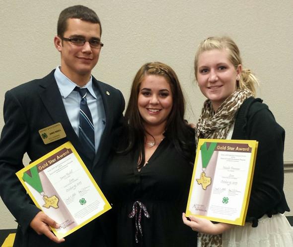 4-H students James Rodell and Natalie Freeman show off their District Gold Stars with Leon County Extension Agent Amanda Shortt.