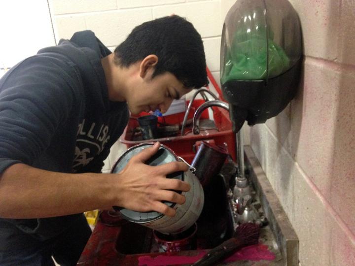 Junior Jesus Cardenas mixes paint while working in the ag shop.
