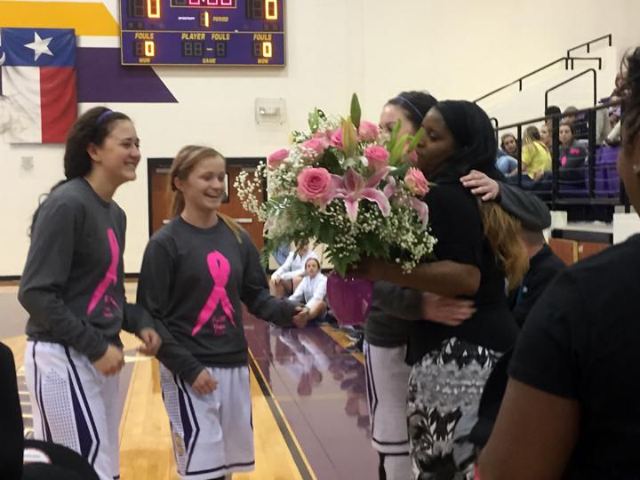 Coach+Jozette+jenkins%2C+who+battled+cancer+during+much+of+last+years+basketball+season%2C+receives+pink+flowers+and+plenty+of+hugs+from+her+team.