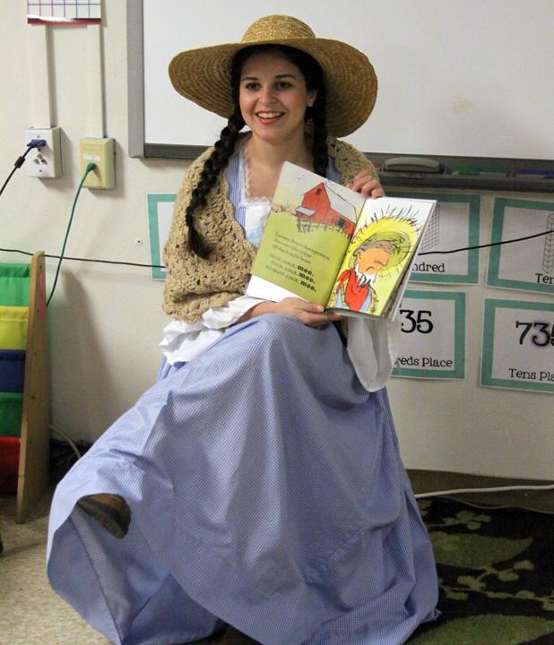 Senior Kendall Morales reads from Click, Clack, Moo while dressed as Farmer Brown's wife.