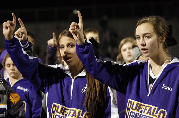 Freshman Sheri Donaldson and fellow cheerleader Tana Cleveland sing the school song at the end of a football game. 