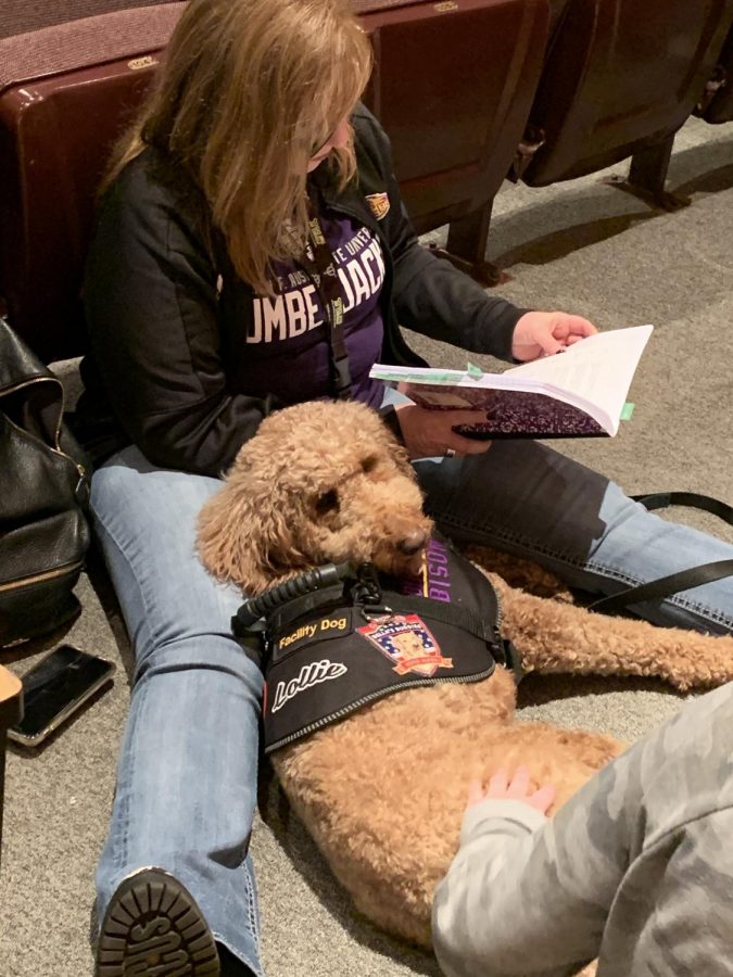 Director Katie Villarreal flips through her script while Lollie relaxes and watches the action onstage. Lollie is the Life Skills emotional support animal, and stays with Villarreal, who teaches Life Skills in addition to theatre.