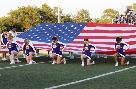 Cheerleader and Belle members showcase the American flag during the pre-game show honoring first responders.