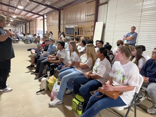 Freshmen at the health fair listen to a speaker before moving to activities.