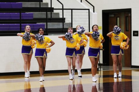 The Bison cheerleaders show off their skills at a volleyball game.