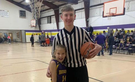 Thomas Grissett poses with his younger sister after his first Little Dribblers game as a referee.