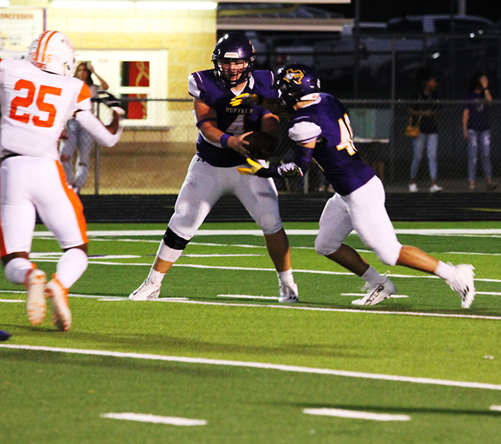 Senior Xander Cheek takes the handoff from senior Zayne Johnson during a home game against Teague.