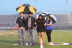 Senior Julissa Lechuga and her family try to stay dry during Senior Walk.