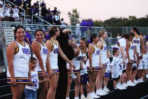 The cheerleaders watch the Bison play during the first set of mini-cheerleader exhibitions. Parents lined the fence to watch the future cheerleaders show off what they learned the day before at camp.
