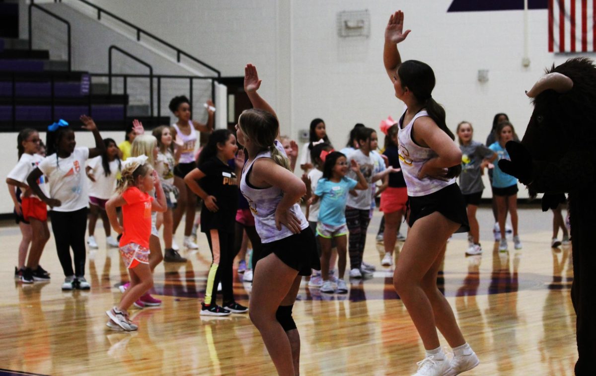 The cheerleaders lead the campers in a warm-up before teaching each group a cheer. Buckys Buddies has become an annual event. 