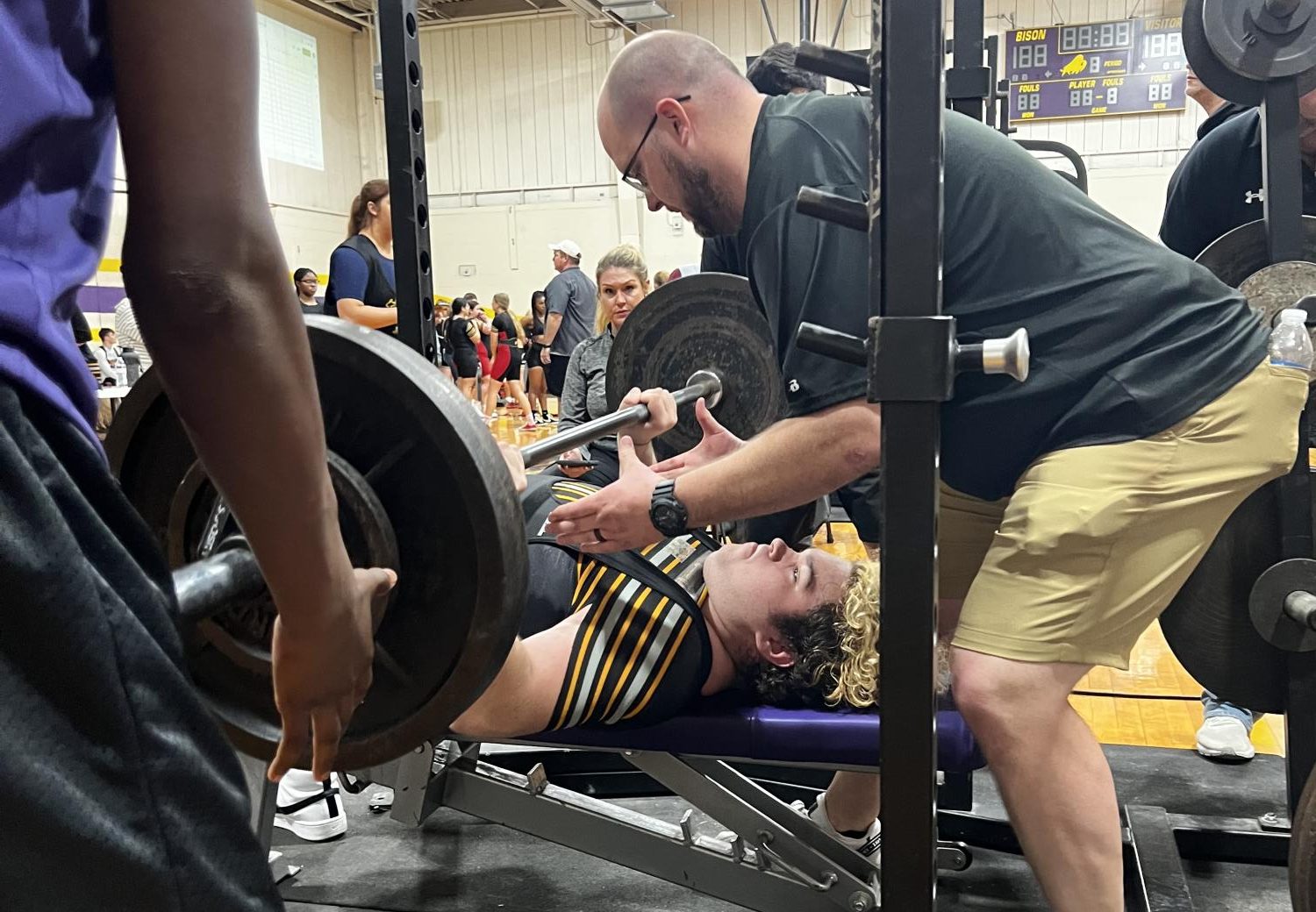 Senior Michael Brauer lifts at a meet last spring with coach James Talley spotting. 