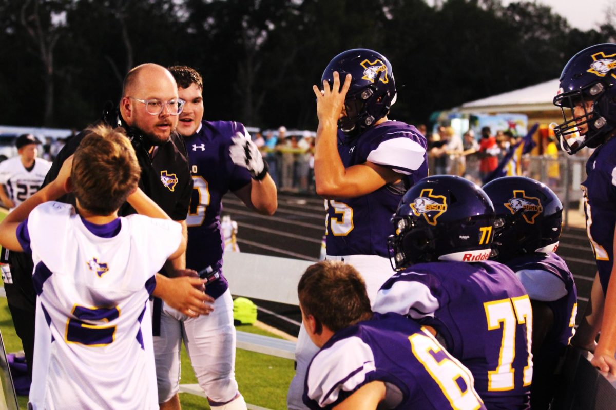 Offensive Coordinator James Talley talks with his players on the sidelines during the homecoming game against Normangee.