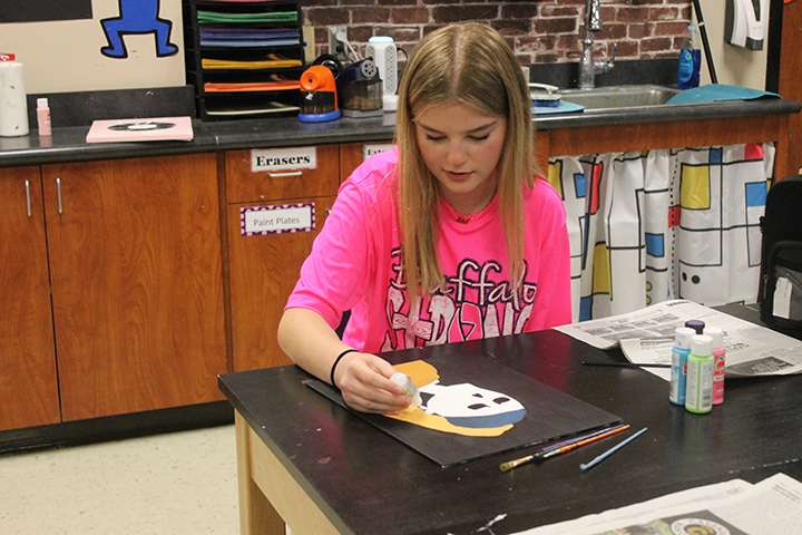 Mikah Kesinger works on her sugar skull painting during art class. The student artwork is currently on display in the 500 hall.