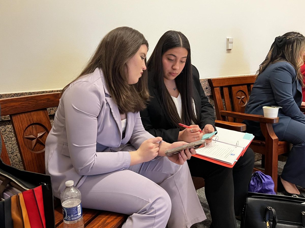 Debaters Nicollette Arabie and Kaylen Sanchez go over their debate prep during a recess at the Texas Capitol. 