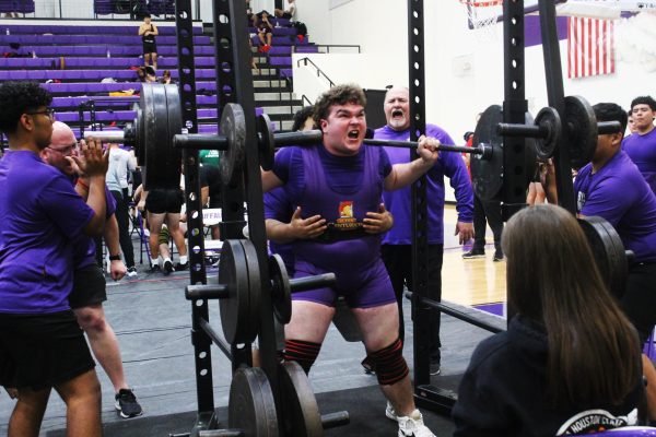 Junior Michael Brauer pushes himself to reach his lift goal while coaches Jesse House and James Talley cheer him on. Tally said that Brauer is one of several members of the team who are on-track to make regionals.