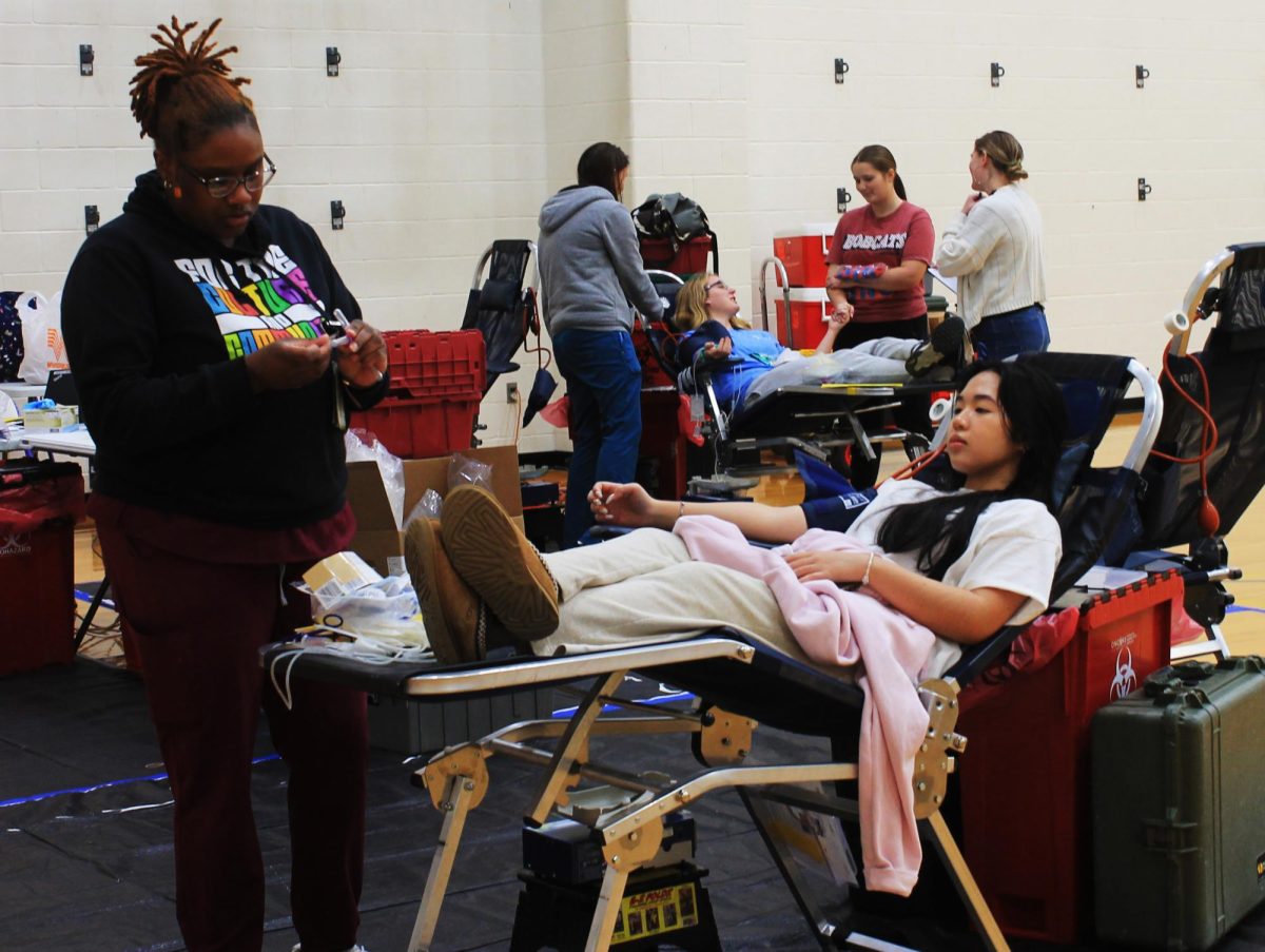 Senior Sharlene Le visits with a tech from Carter Blood Care while she donates at one of this years NHS blood drives.