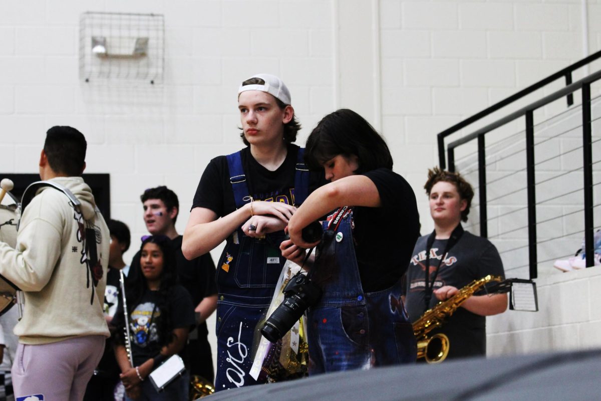 Senior Ryan Brown checks the pictures they have taken during a pep rally while photographing the event with classmate Mason Ayles. Brown hopes to medal at state in journalism again this year.