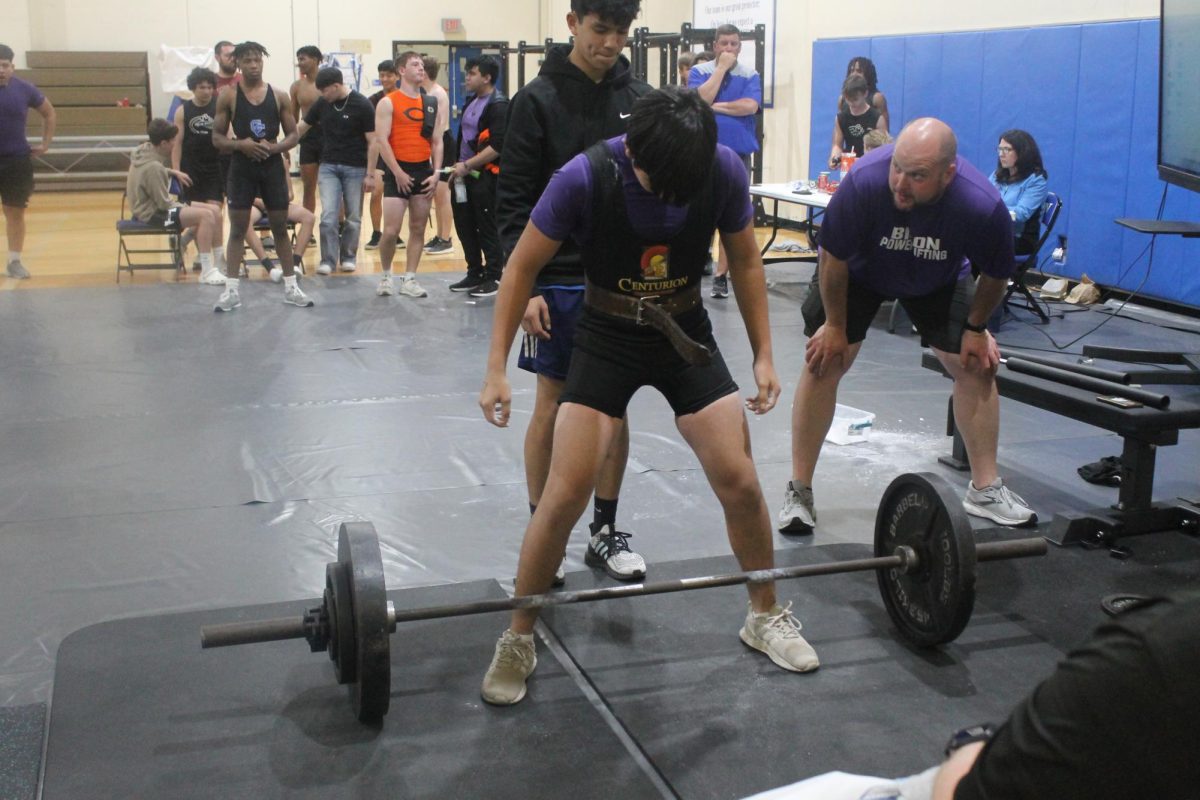 Coach+James+Talley+works+with+an+athlete+who+is+about+to+lift+at+the+Leon+tournament.+Four+lifters+qualified+for+regionals+this+year.