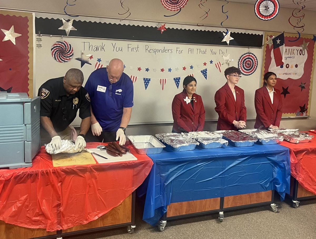 School police chief Mitchell Gatson helps FCCLA officers and volunteers get ready to serve first responders at the annual luncheon last week. 