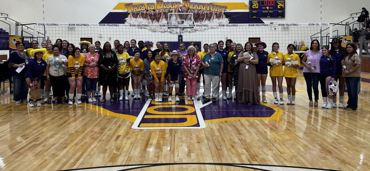 Teachers and players post for a picture after they are announced on the court. 