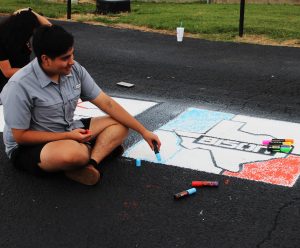 Senior Natanael Montano works on his Bison while the seniors painted the parking lot.