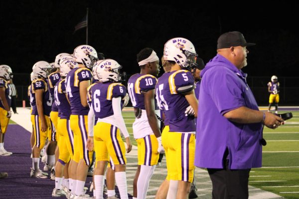 Football coach Jeremy Evans and several of the Bison players watch the action on the field during the game against Winona. The Bison took a narrow loss.