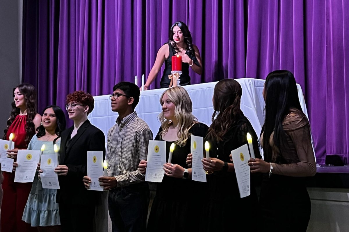 Junior Alexa Sanchez crosses the stage as she lights her candle to be inducted into the Spanish Honor Society.